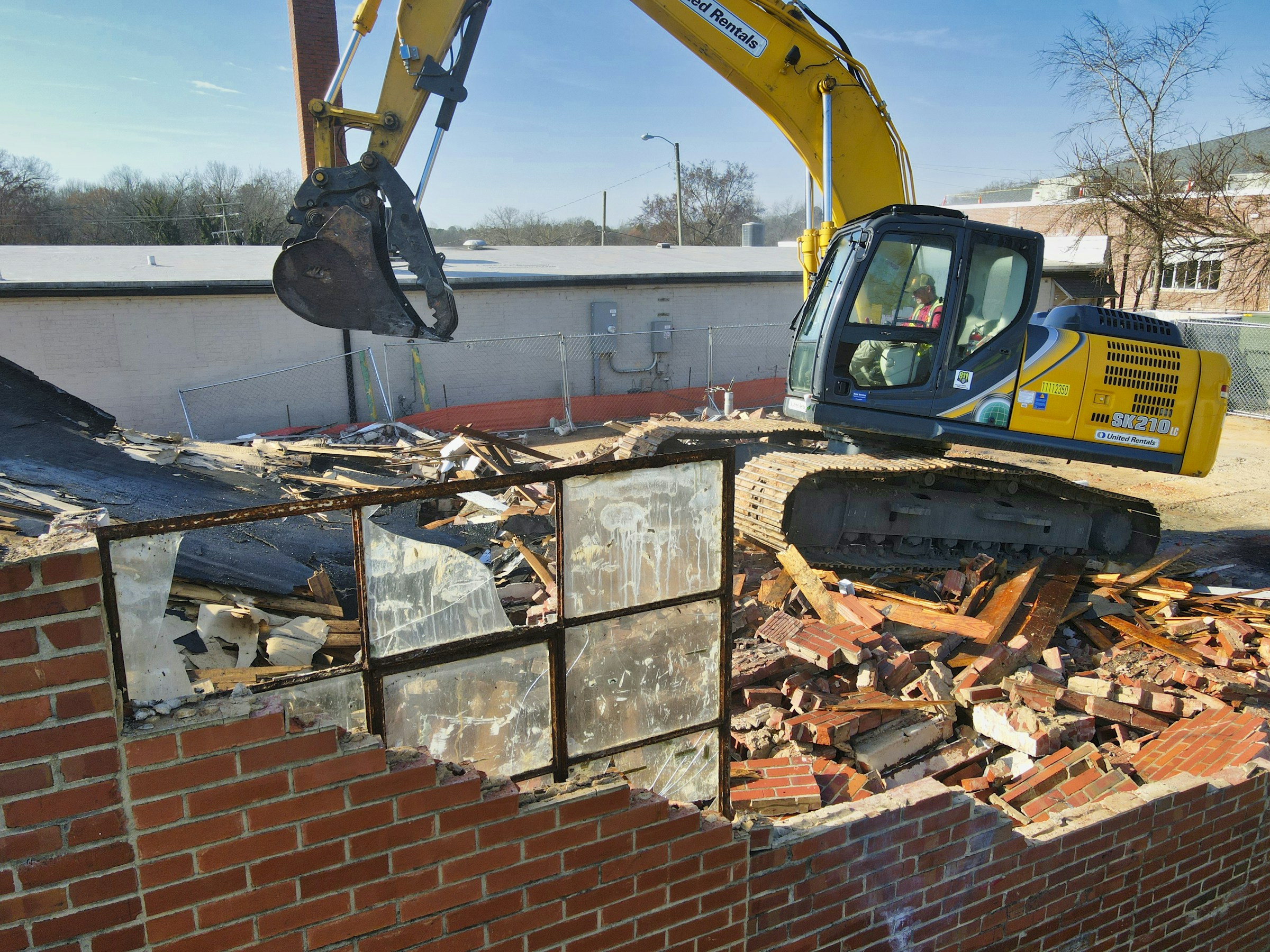 Excavator demolishing brick structure β break-out and removal