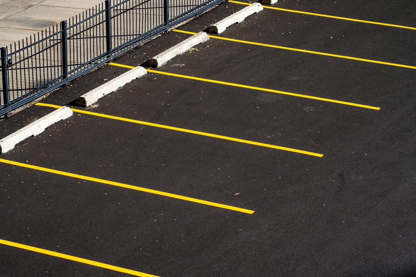 Commercial carpark with yellow line markings and wheel stops