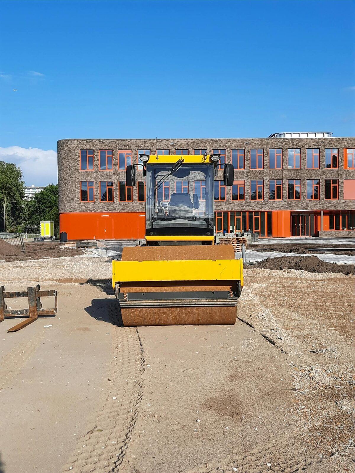 Drum roller compacting subgrade on civil pad