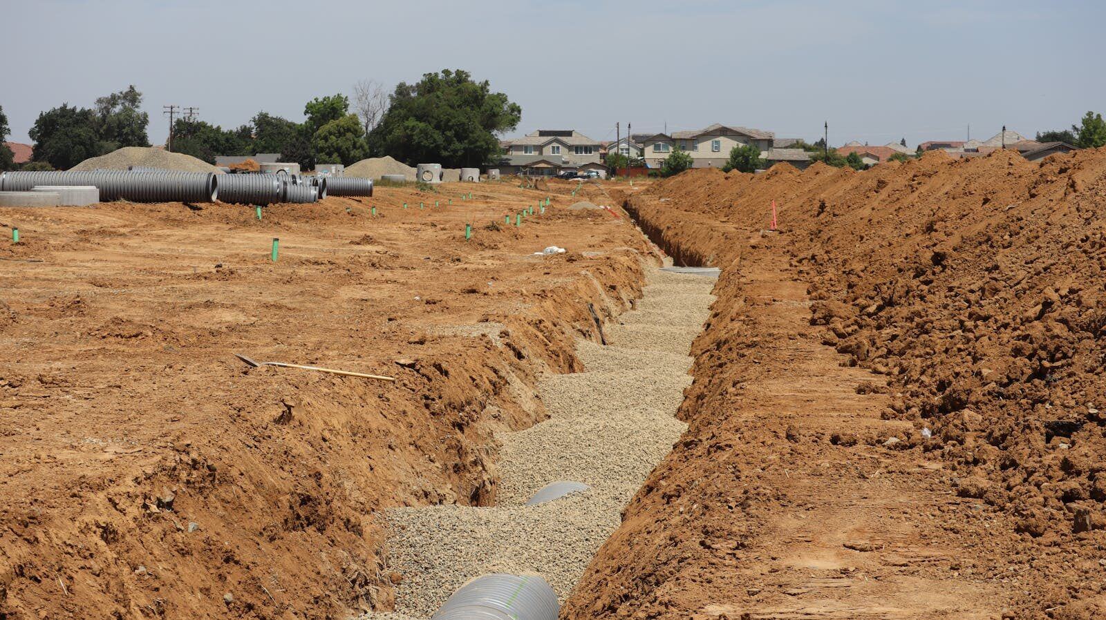 Utility trench with aggregate bedding before pipe install